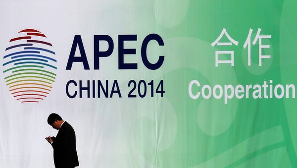 A man walks past a wall bearing a logo of the 2014 Asia Pacific Economic Cooperation (APEC) at the venue for APEC CEO Summit while its opening ceremony is being held in Beijing November 9, 2014. - Sputnik International