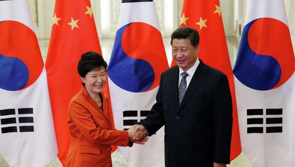 China's President Xi Jinping (R) shakes hands with South Korea's President Park Geun-hye in front of Chinese and South Korean national flags during a meeting at the Great Hall of the People, on the sidelines of the Asia Pacific Economic Cooperation (APEC) meetings, in Beijing, November 10, 2014. - Sputnik International