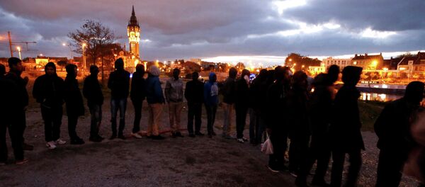 Migrants queue for the daily food distribution close to the city hall in Calais October 26, 2014 Migrants queue for the daily food distribution close to the city hall in Calais October 26, 2014 - Sputnik International