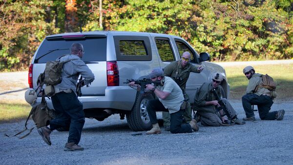 Members of the US Diplomatic Security Service take cover and return fire during a simulated ambush on a motorcade during a High Threat training program held at a mock town named Erehwon, nowhere spelled backwards, on a rural Virginia military base, Thursday, Oct. 9, 2014 - Sputnik International