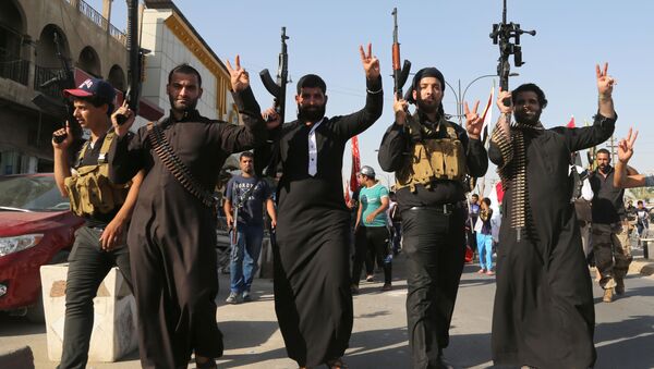 Shiite tribal fighters raise their weapons and chant slogans against the al-Qaida-inspired Islamic State of Iraq and the Levant (ISIL) in the northwest Baghdad's Shula neighborhood, Iraq, Monday, June 16, 2014. Sunni militants captured a key northern Iraqi town along the highway to Syria early on Monday, compounding the woes of Iraq's Shiite-led government a week after it lost a vast swath of territory to the insurgents in the country's north. - Sputnik International