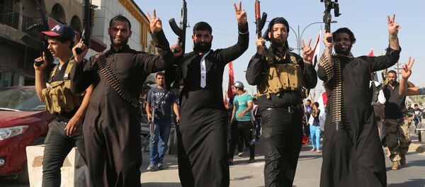 Shiite tribal fighters raise their weapons and chant slogans against the al-Qaida-inspired Islamic State of Iraq and the Levant (ISIL) in the northwest Baghdad's Shula neighborhood, Iraq, Monday, June 16, 2014. Sunni militants captured a key northern Iraqi town along the highway to Syria early on Monday, compounding the woes of Iraq's Shiite-led government a week after it lost a vast swath of territory to the insurgents in the country's north. Shiite tribal fighters raise their weapons and chant slogans against the al-Qaida-inspired Islamic State of Iraq and the Levant (ISIL) in the northwest Baghdad's Shula neighborhood, Iraq, Monday, June 16, 2014. Sunni militants captured a key northern Iraqi town along the highway to Syria early on Monday, compounding the woes of Iraq's Shiite-led government a week after it lost a vast swath of territory to the insurgents in the country's north. - Sputnik International