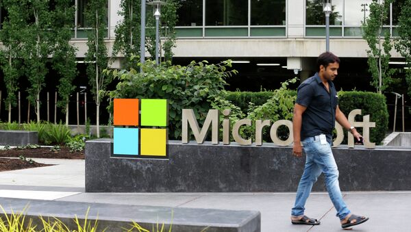 In this photo taken July 3, 2014, a worker walks past a Microsoft logo outside the Microsoft Visitor Center in Redmond, Wash - Sputnik International