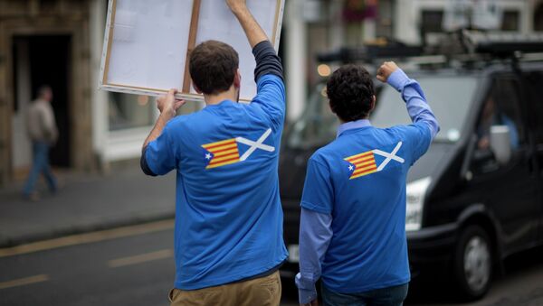 David Aguilar, left, and Aleix Sarri from Catalonia, who are visiting Scotland to support the Scottish independence referendum, gesture and hold up a placard supporting a Yes vote at passing motorists in Edinburgh, Scotland, Thursday, Sept. 18, 2014 - Sputnik International