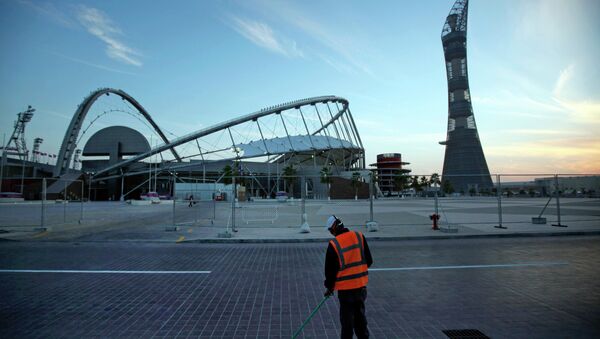 A worker cleans the road outside Khalifa sport complex in Doha, Qatar - Sputnik International