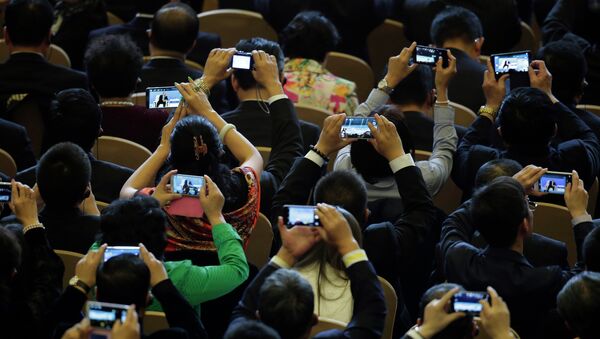 Delegates use their smartphones to take pictures of Russian President Vladimir Putin speaks during a dialogue session with delegates during the APEC CEO Summit - Sputnik International