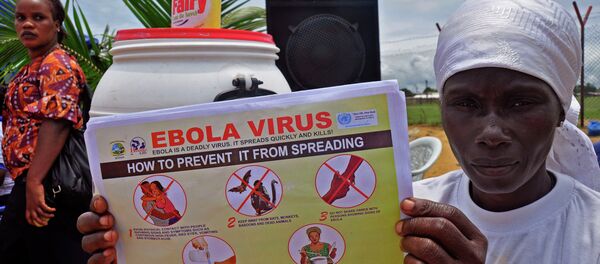 A Liberian woman holds up a pamphlet with guidance on how to prevent the Ebola virus from spreading, in the city of Monrovia, Liberia. A Liberian woman holds up a pamphlet with guidance on how to prevent the Ebola virus from spreading, in the city of Monrovia, Liberia. - Sputnik International