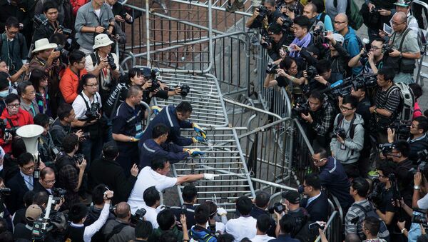 Building employees dismantle a barricade outside Citic Tower in accordance with a court injunction to clear up part of the protest site, outside the government headquarters in Hong Kong November 18, 2014. - Sputnik International