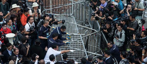 Building employees dismantle a barricade outside Citic Tower in accordance with a court injunction to clear up part of the protest site, outside the government headquarters in Hong Kong November 18, 2014. - Sputnik International