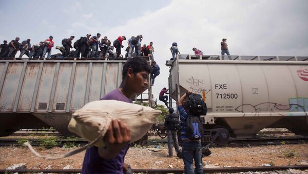 Migrants coming from Central America climb off a train during their journey toward the U.S.-Mexico border in Ixtepec, Mexico, Monday, April 29, 2013 - Sputnik International