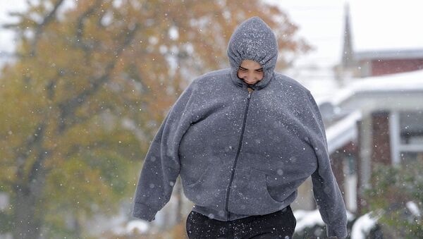 With his arms tucked inside his hooded sweatshirt, Aris Espinosa, 16, of Erie, Pa. walks to school, Tuesday, Nov. 18, 2014 in Erie, Pa. A lake-effect snowstorm dumped up to 4 feet of snow along a stretch of the New York State Thruway on Tuesday - Sputnik International