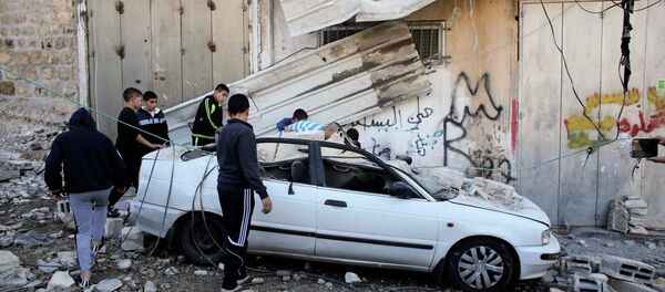 Palestinians stand next to a car damaged during the demolition of Abdel-Rahman Shaloudi's home in the East Jerusalem neighbourhood of Silwan November 19, 2014 Palestinians stand next to a car damaged during the demolition of Abdel-Rahman Shaloudi's home in the East Jerusalem neighbourhood of Silwan November 19, 2014 - Sputnik International