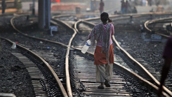 An Indian woman walks after defecating on a railway track, on World Toilet Day in Gauhati, India, Wednesday, Nov. 19 2014 - Sputnik International