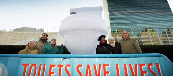 A small group of UN staff, with a “Toilets Save Lives!” banner, poses for a photo with a 15-foor-high inflatable toilet, in front of United Nations headquarters A small group of UN staff, with a “Toilets Save Lives!” banner, poses for a photo with a 15-foor-high inflatable toilet, in front of United Nations headquarters - Sputnik International