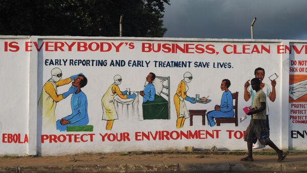 A man walks by a mural with health instructions on treating the Ebola virus, in Monrovia, November 18, 2014 - Sputnik International