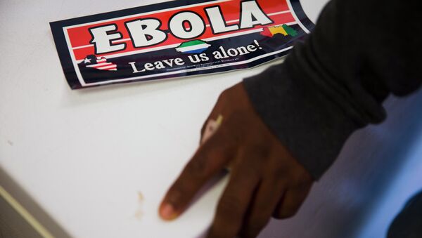 An Ebola bumper sticker sits next to Sierra Leone immigrant Mamud Jalloh's hand Wednesday, Oct. 8, 2014, in Philadelphia - Sputnik International