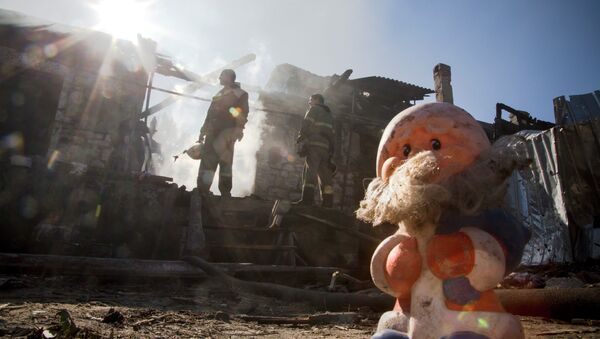 Firefighters inspect a burned house after shelling in the town of Donetsk, eastern Ukraine, - Sputnik International