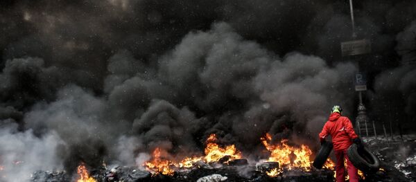 A protester adds tire to the fire in Maidan square in Kiev, Ukraine, Jan 22, 2014 A protester adds tire to the fire in Maidan square in Kiev, Ukraine, Jan 22, 2014 - Sputnik International