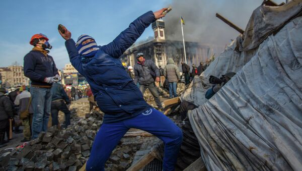 A protester throws stone on Maidan square in Kiev, Ukraine, Feb 19, 2014 - Sputnik International
