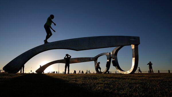 Children play under a sculpture in the form of a giant pair of spectacles on Cape Town's Sea Point Promenade, November 18, 2014 - Sputnik International