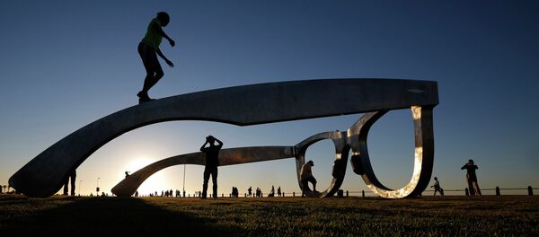 Children play under a sculpture in the form of a giant pair of spectacles on Cape Town's Sea Point Promenade, November 18, 2014 - Sputnik International