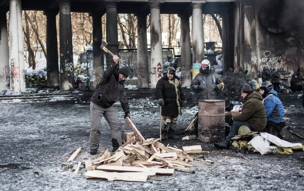 An opposition supporter chops firewood near a barricade on Grushevskogo Street in Kiev. - Sputnik International