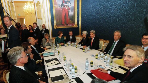 French Foreign Minister Laurent Fabius, sitting third left, former EU foreign policy chief Catherine Ashton, rear center, U.S. Secretary of State John Kerry, fourth right, and British Foreign Secretary Philip Hammond wait for the start of closed-door nuclear talks on Iran in Vienna, Austria, Friday, Nov. 21, 2014 - Sputnik International