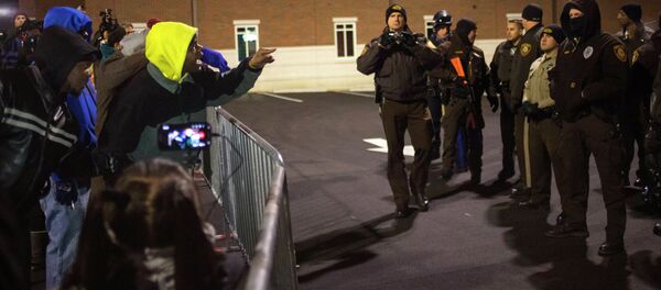 A police officer was shot in the arm as violence grows amid protesters angry with the grand jury's ruling not to press charges against the policeman who killed Michael Brown. - Sputnik International