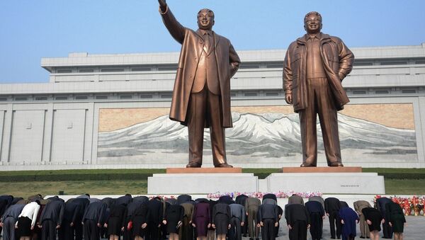 Pyongyang, North Korea: North Koreans bow in-front of statues of the former leaders Kim Il-sung (left) and Kim Jong-il (right) at the Mansudae Grand Monuments - Sputnik International