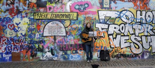 A street musician plays a guitar by Prague's famous Lennon Wall A street musician plays a guitar by Prague's famous Lennon Wall - Sputnik International