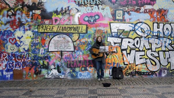 A street musician plays a guitar by Prague's famous Lennon Wall - Sputnik International