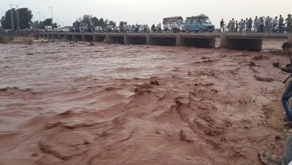 This image taken with a mobile phone shows residents of Guelmim, south western Morocco, crossing a bridge over floodwaters - Sputnik International