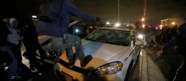 Protesters vandalize a police car outside the Ferguson Police Department in Ferguson, Missouri, after a grand jury returned no indictment in the shooting of Michael Brown Protesters vandalize a police car outside the Ferguson Police Department in Ferguson, Missouri, after a grand jury returned no indictment in the shooting of Michael Brown - Sputnik International