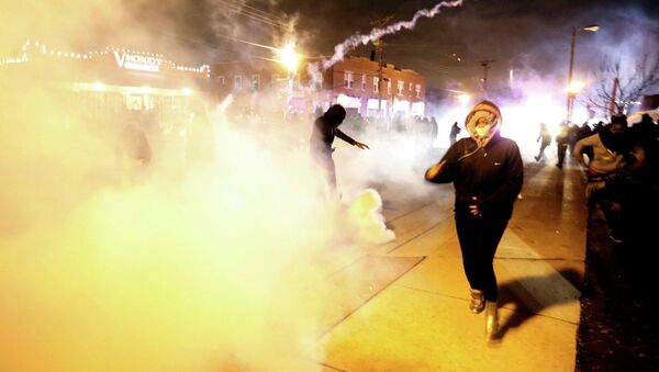 Protesters run from a cloud of tear gas after a grand jury returned no indictment in the shooting of Michael Brown in Ferguson, Missouri. - Sputnik International