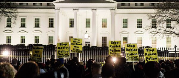 Protesters demonstrate after the decision by a Missouri grand jury not to indict a white Ferguson police officer in the fatal shooting of unarmed black teenager Michael Brown, in front of the White House in Washington Protesters demonstrate after the decision by a Missouri grand jury not to indict a white Ferguson police officer in the fatal shooting of unarmed black teenager Michael Brown, in front of the White House in Washington - Sputnik International