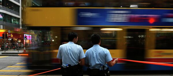 A bus drives past two policemen at the main Nathan Road after normal traffic resumed, at Mongkok shopping district in Hong Kong A bus drives past two policemen at the main Nathan Road after normal traffic resumed, at Mongkok shopping district in Hong Kong - Sputnik International