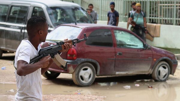 The eastern Libyan city of Derna residents are terrorized by the Islamic Youth Shura Council extremist group, which has pledged allegiance to Islamic State militants in Syria and Iraq. Above: A man with an armed group of Libyan people holds a weapon to defend their local area from Islamic. - Sputnik International