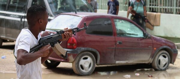 A man with an armed group of Libyan people holds a weapon to defend their local area from Islamic militias in Benghazi, Libya, Thursday, Oct. 23, 2014 - Sputnik International