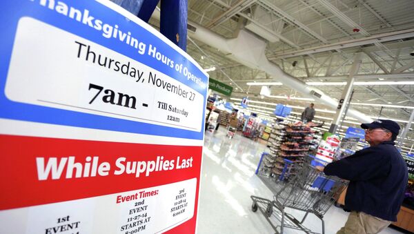 A man walks near a sign at Walmart as the store prepares for Black Friday in Los Angeles, California November 24, 2014 - Sputnik International