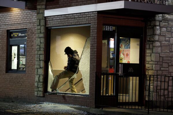 A man steps out of a vandalized store after the announcement of the grand jury decision in Ferguson A man steps out of a vandalized store after the announcement of the grand jury decision in Ferguson - Sputnik International