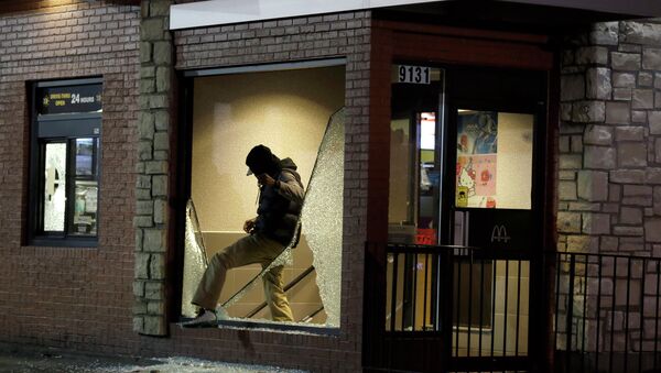 A man steps out of a vandalized store after the announcement of the grand jury decision in Ferguson - Sputnik International