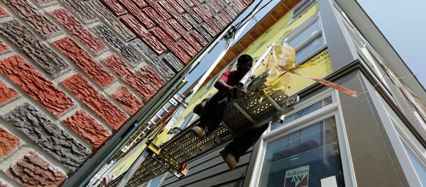 In this Friday, Aug. 17, 2012, file photo, a worker adjusts a scaffold at the site of a new residential construction project in the East Boston neighborhood of Boston - Sputnik International