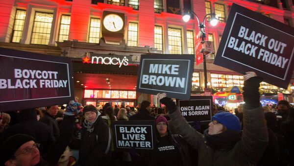 Protesters hold signs aloft outside Macy's before the kick off of Black Friday sales in New York November 27, 2014 - Sputnik International