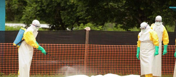 Medical workers are disinfecting the dead body of an Ebola patient. Medical workers are disinfecting the dead body of an Ebola patient. - Sputnik International