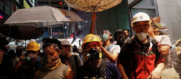 Protesters protect themselves from being sprayed with tear spray during a confrontation with riot police at Mongkok shopping district in Hong Kong Protesters protect themselves from being sprayed with tear spray during a confrontation with riot police at Mongkok shopping district in Hong Kong - Sputnik International