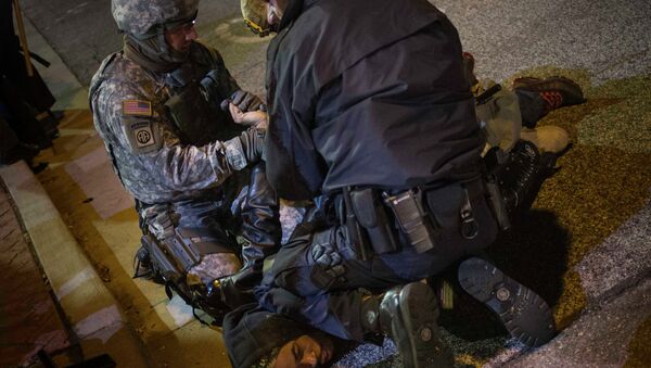 A policeman and member of the National Guard detain a man, who was demanding justice for the killing of 18-year-old Michael Brown, outside the Ferguson Police Department in Missouri November 28, 2014. - Sputnik International