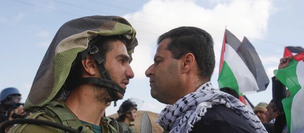 An Israeli soldier argues with a Palestinian protester as they try to block a highway between Jerusalem and the Dead Sea near the West Bank town of Jericho Friday, Nov. 28, 2014. An Israeli soldier argues with a Palestinian protester as they try to block a highway between Jerusalem and the Dead Sea near the West Bank town of Jericho Friday, Nov. 28, 2014. - Sputnik International