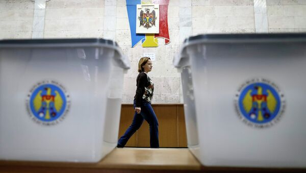 Ballot boxes are seen as a member of a local electoral commission passes by at a polling station in Chisinau November 29, 2014. - Sputnik International