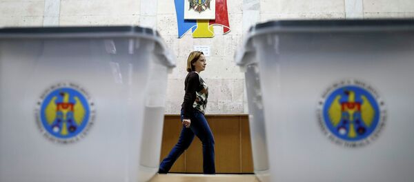 Ballot boxes are seen as a member of a local electoral commission passes by at a polling station in Chisinau November 29, 2014. - Sputnik International