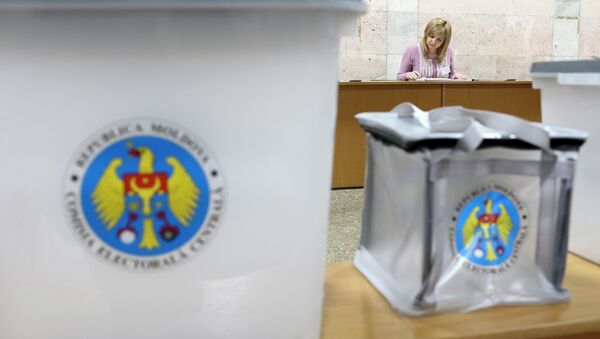 Ballot boxes are seen as a member of a local electoral commission works with papers at a polling station in Chisinau November 29, 2014 - Sputnik International